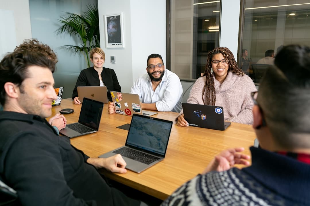 A group of professionals in a meeting discussing referral pathways, emphasizing collaboration in speech-language pathology marketing.