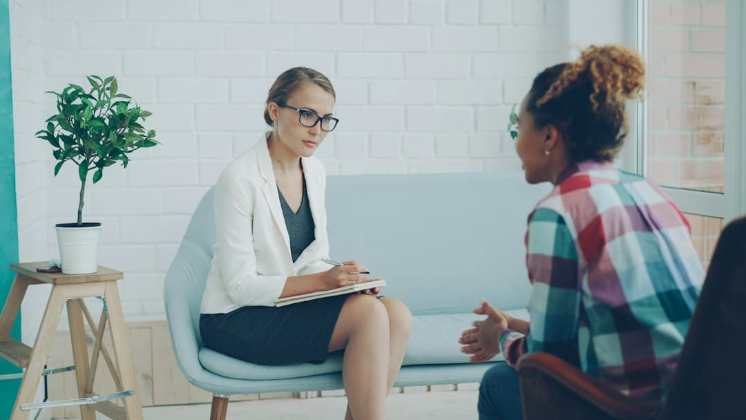 A therapist meeting with a couple in a modern office, discussing therapy goals and strategies.