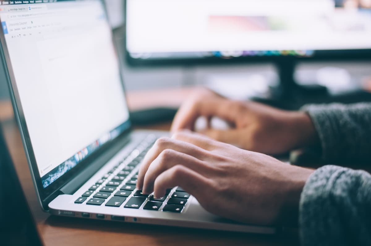 Close-up of hands typing on a laptop while tracking marketing KPIs and lead flow