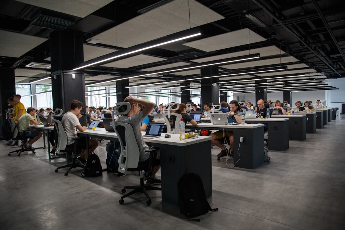 Creative team working together at a shared desk with laptops in a modern workspace