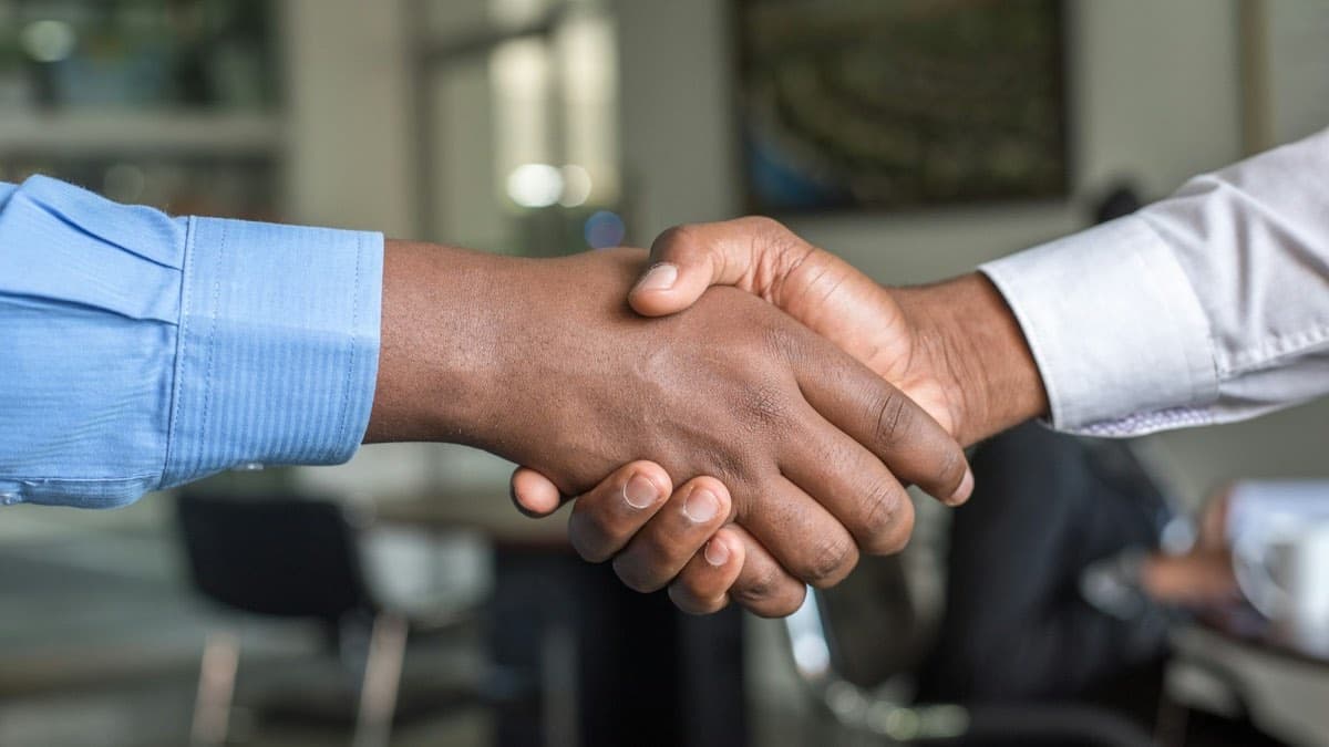 Two professionals shaking hands in an office, the colleague relationship that sends private therapy referrals in Ontario